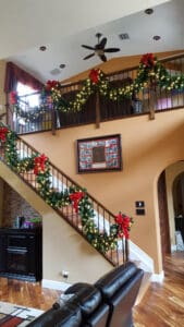 Indoor staircase Christmas garland and lights installation by Christmas Decor in Boynton Beach